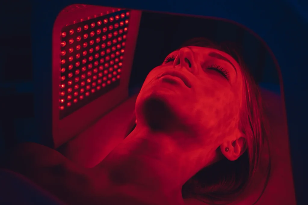 Person lying in Regenesis ExoRed red light therapy bed at Sisu Longevity Studio in Colorado Springs