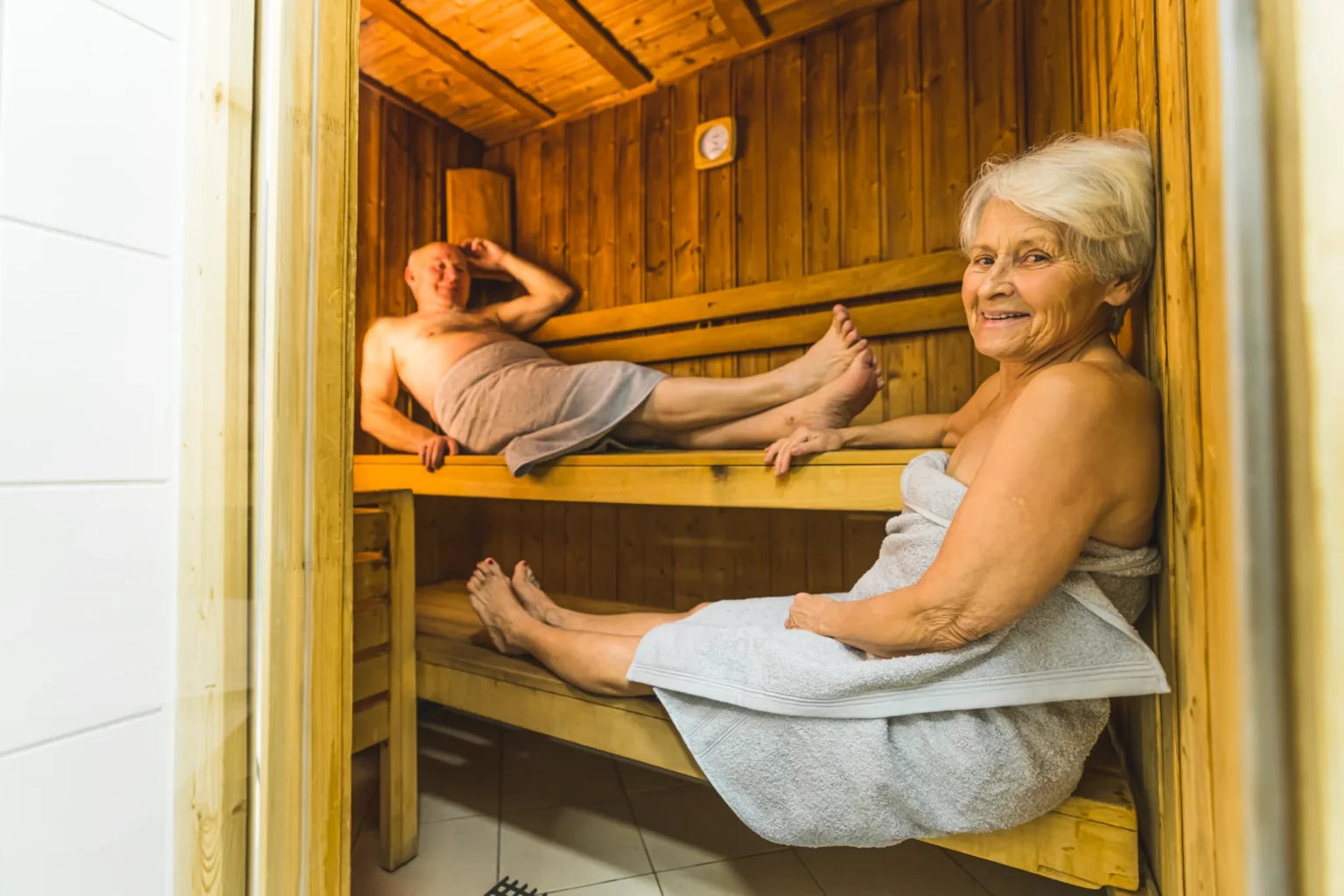 Elderly couple enjoying a sauna session, promoting wellness and longevity at Sisu Longevity Studio.