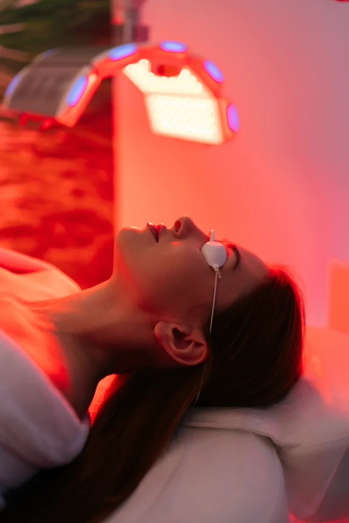 A woman undergoing a relaxing light therapy session at Sisu Longevity Studio.