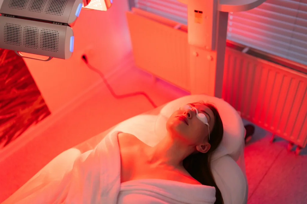 A person relaxing under red light therapy for wellness and recovery at Sisu Longevity Studio.