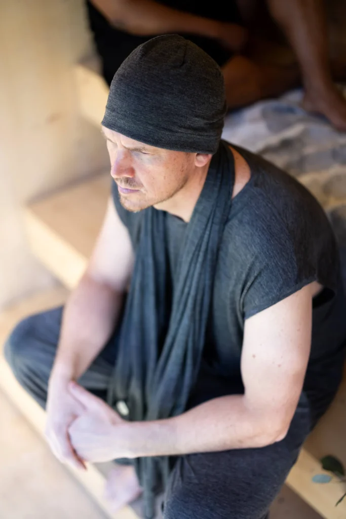 Person sitting in a sauna, embodying wellness and inner strength.