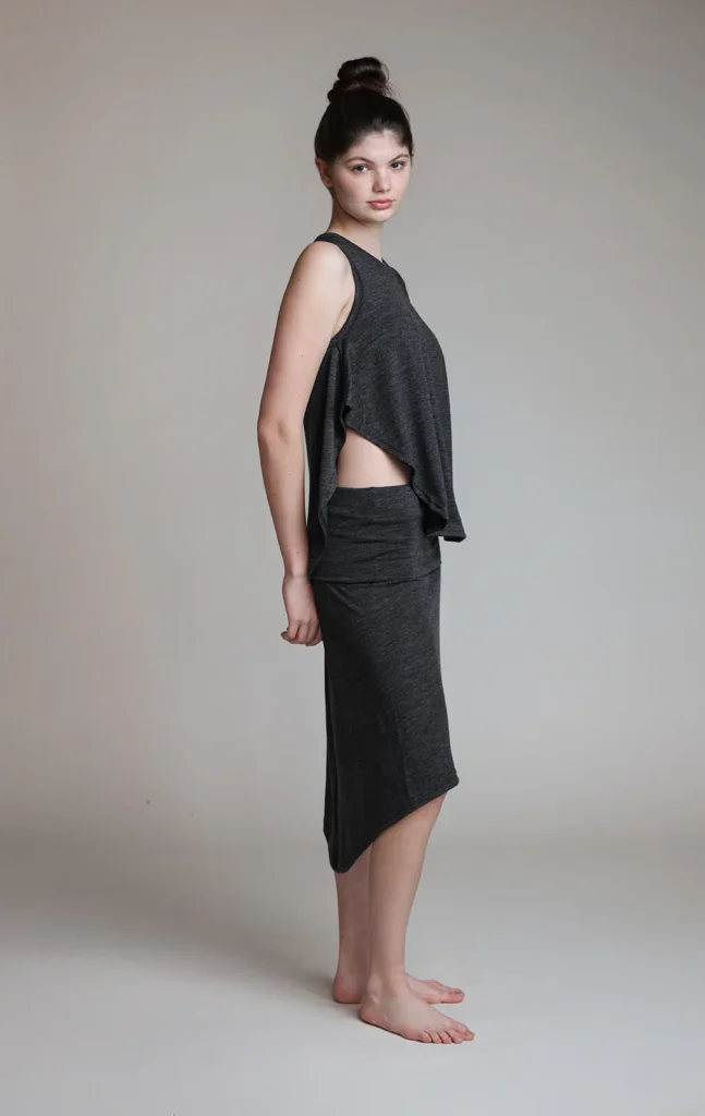 A woman in a relaxed pose wearing dark, comfortable clothing suitable for wellness and recovery activities at Sisu Longevity…