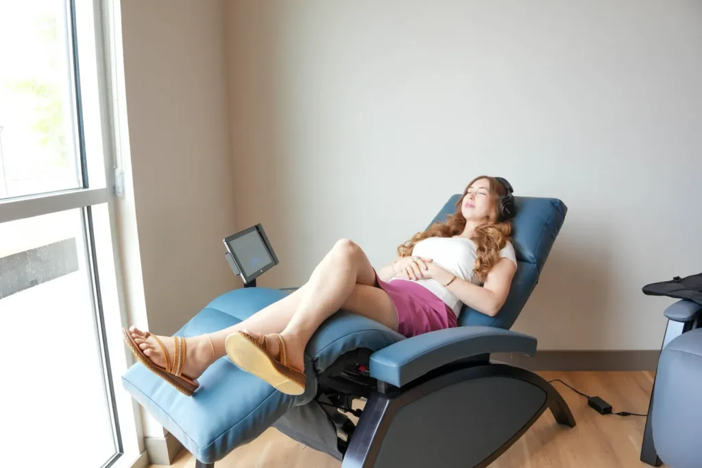 Client relaxing on the vibroacoustic therapy lounger with headphones at Sisu Longevity Studio